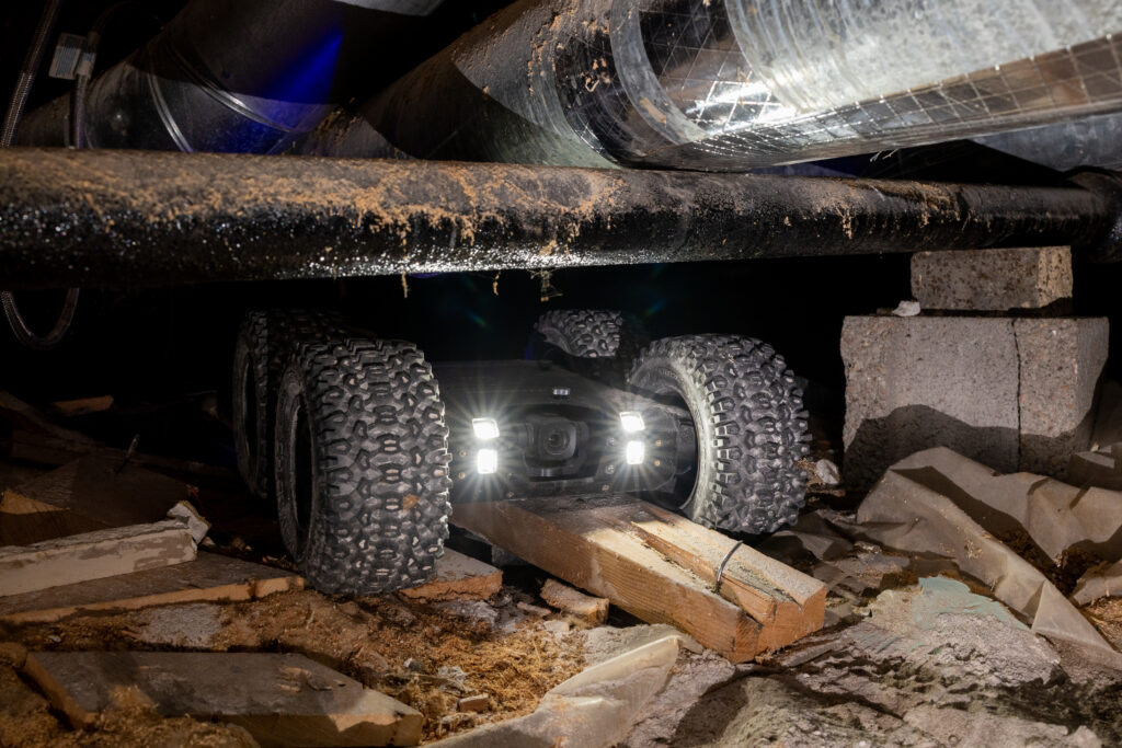 Crawlspace inspection robot navigating a low-access area beneath a home